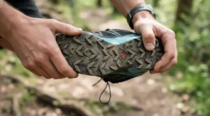 Inspecting the rubber outsole of worn racing flats for marathon durability check.