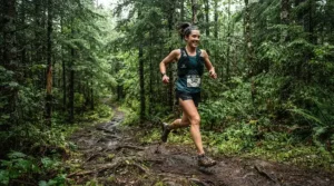 A trail runner wearing durable men's running shorts on a rugged dirt path through the woods.